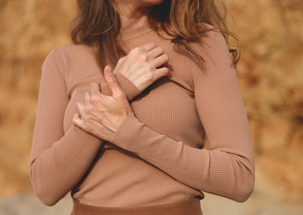 woman in beige posing on the beach. hands closeup.